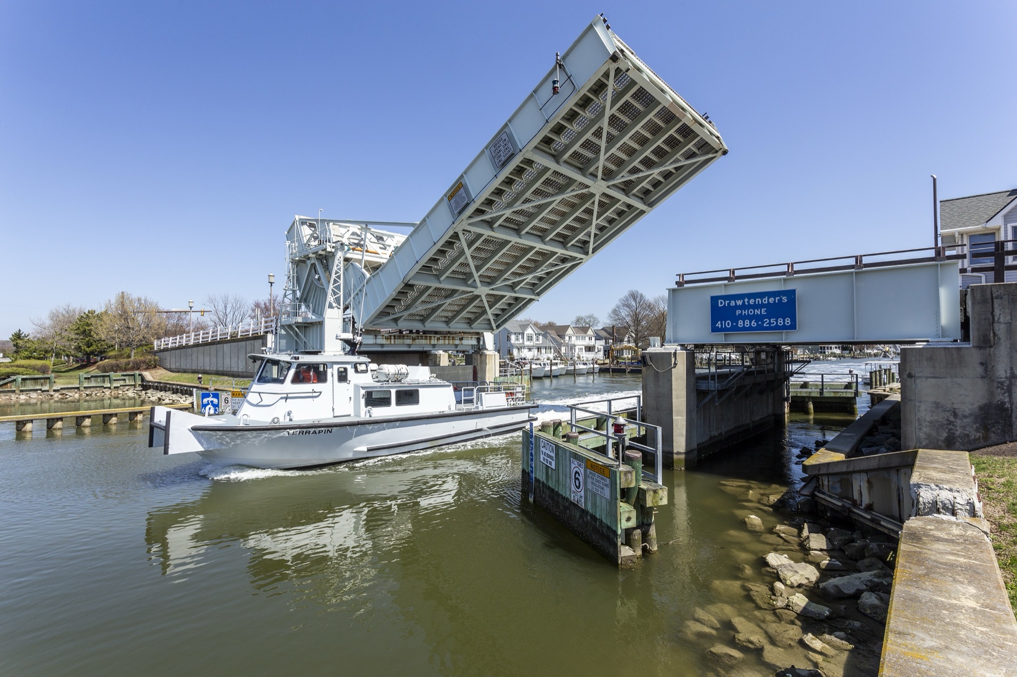 A boat passing under the raised drawbridge at Knapps Narrows, Tilghman Island, Maryland