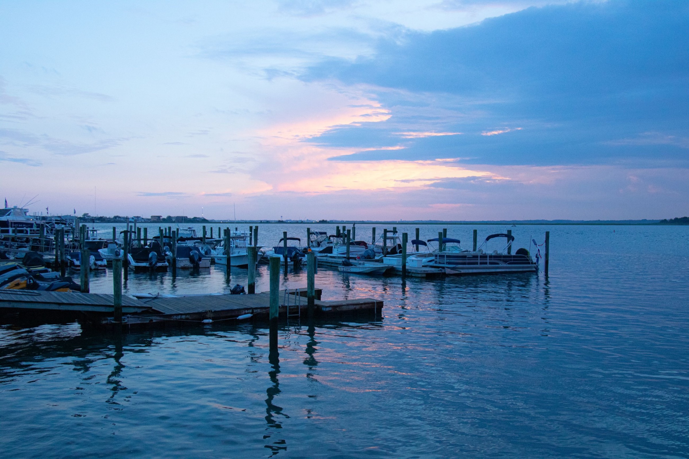 A harbor on Maryland's Eastern Shore at golden hour, boats moored as the sun sets.